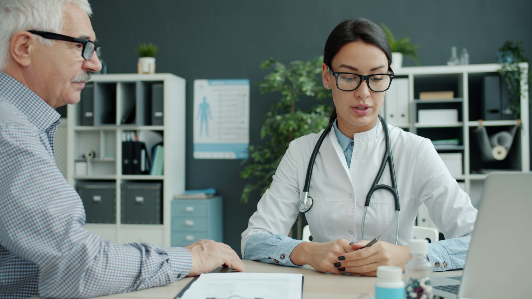 A caring doctor checking an older adult patient's blood pressure